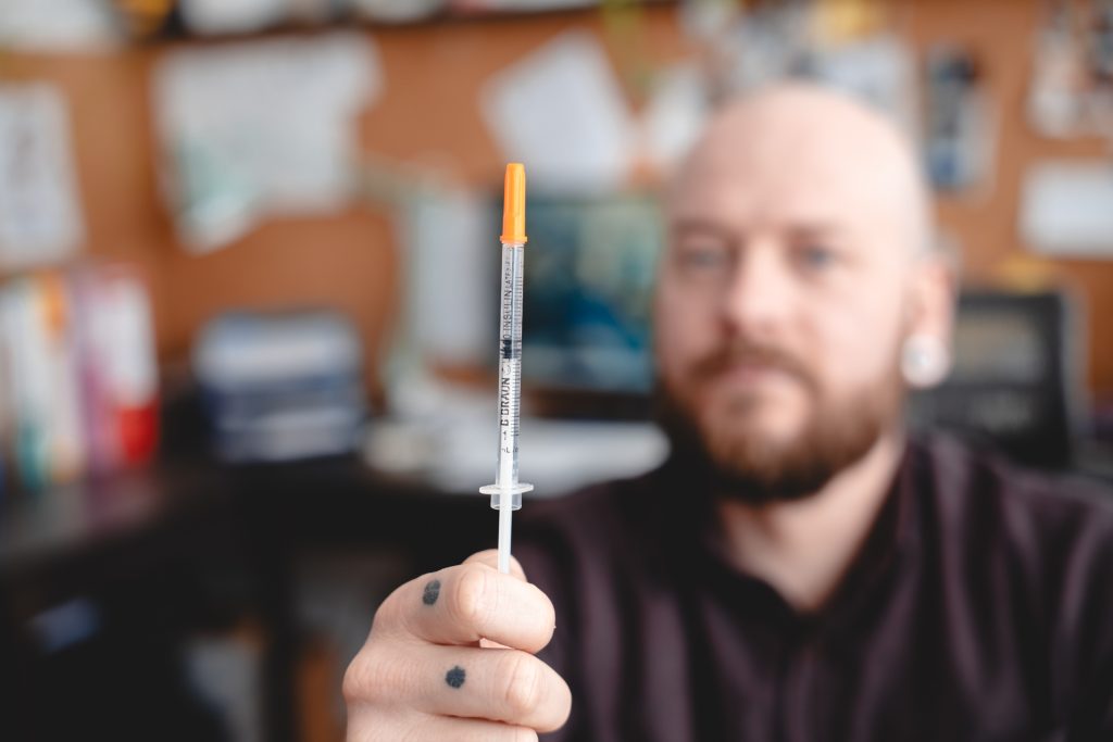 Fotografia injekčnej striekačky, na fotografii Pavol Ščasný